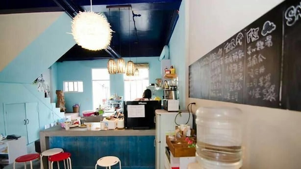 A kitchen area with a bar counter, stools, and a chalkboard menu. - Taroko Susi Space (Xincheng)