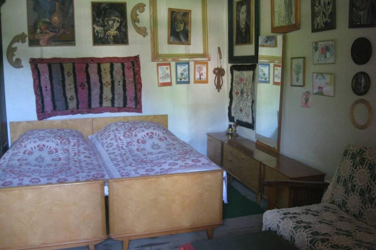 A bedroom with two beds, a dresser, and a mirror.