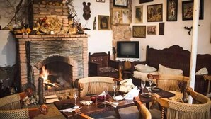 Un salon chaleureux avec une cheminée, des meubles en osier et un téléviseur.