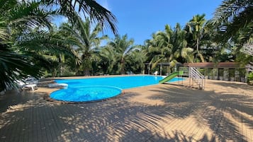 Una piscina al aire libre, sillones reclinables de piscina