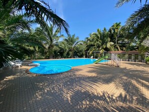 A swimming pool surrounded by palm trees and a covered area with stairs. - Lamphurai Riverside Resort and Spa (Khao Saming)