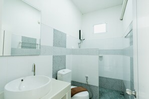 A modern bathroom with a white sink, a toilet, and a shower area. - Lamphurai Riverside Resort and Spa (Khao Saming)