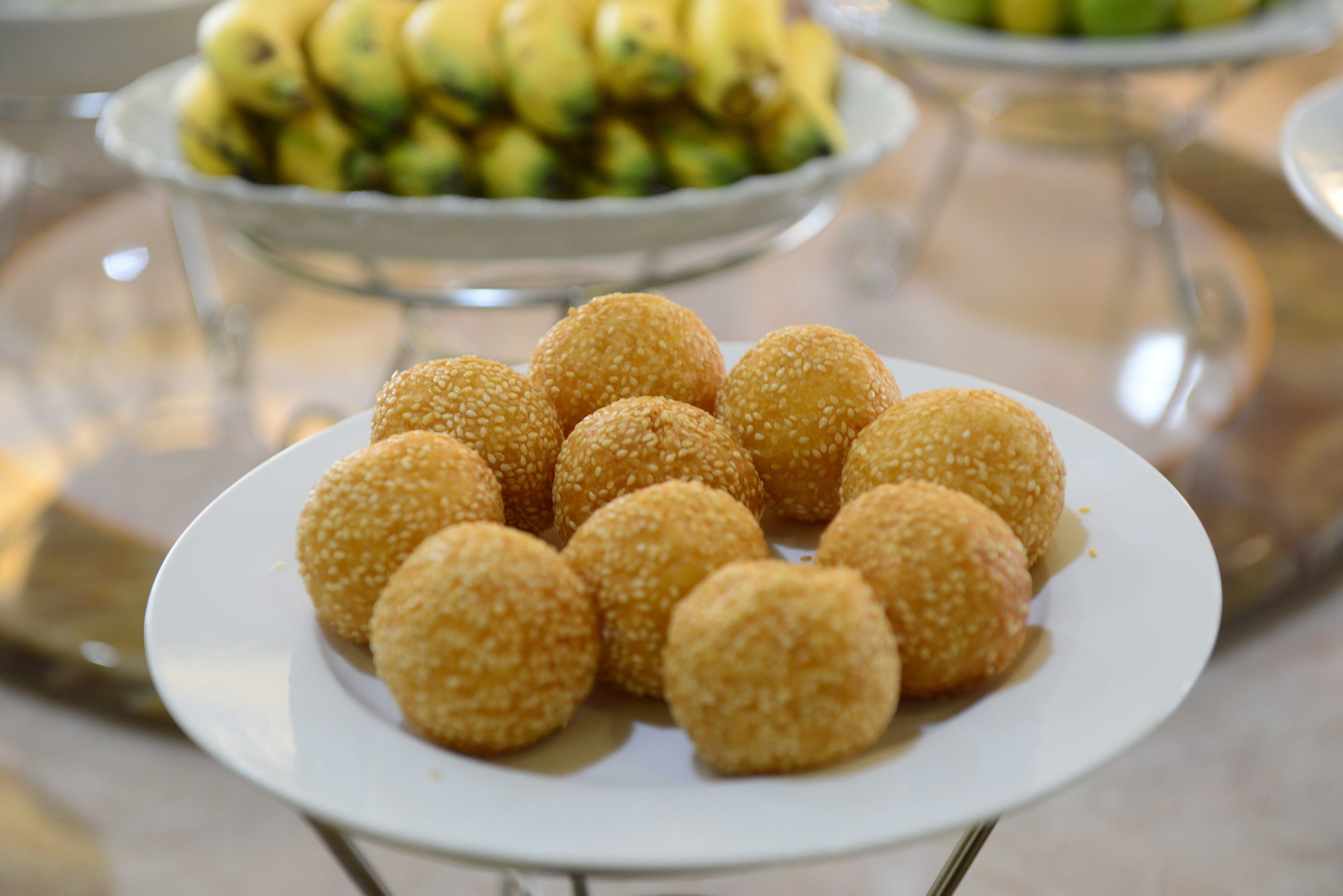 A plate of sesame seed balls on a white plate.
