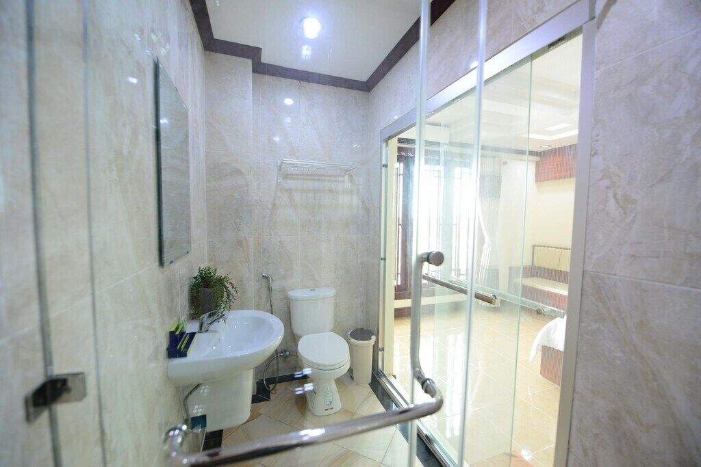 Un baño moderno con cabina de ducha de vidrio, lavabo e inodoro.