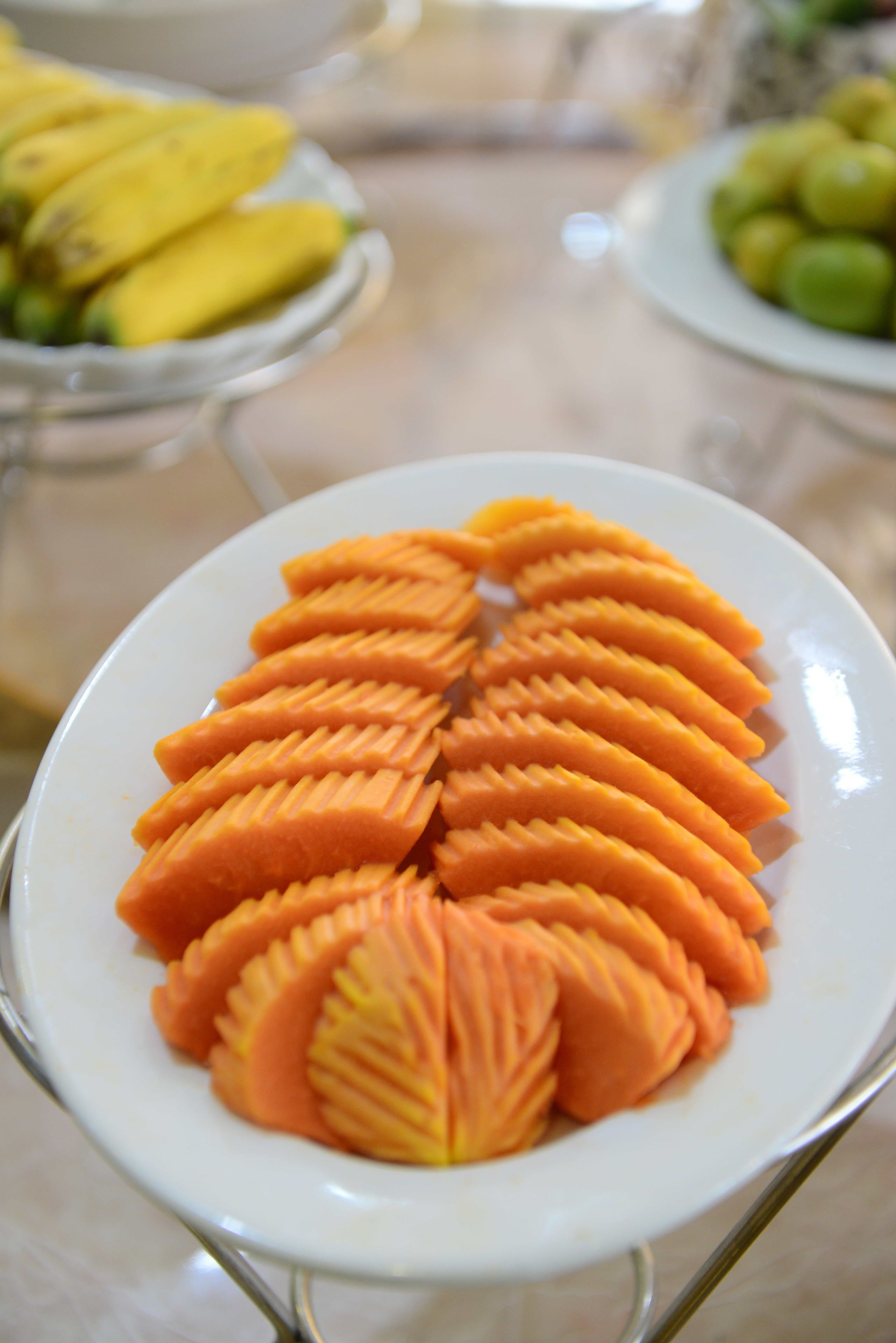 A plate of carved mango slices arranged in a circular pattern.