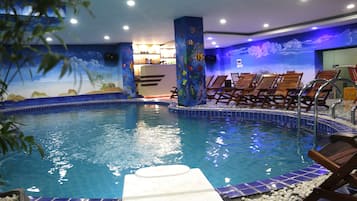 Una piscina cubierta, tumbonas