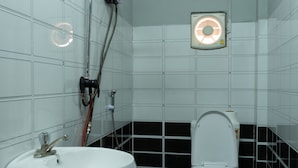 Et badeværelse med en hvid vask, toilet og et vægmonteret varmeelement.