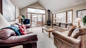 A cozy living room with a fireplace, leather sofas, and a television.