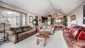 A spacious living room with a large window, a fireplace, and a dining area.