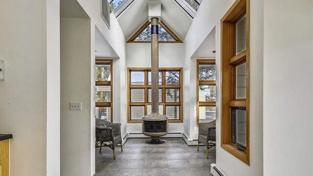 Un pasillo amplio con chimenea, ventanas grandes y tragaluces.
