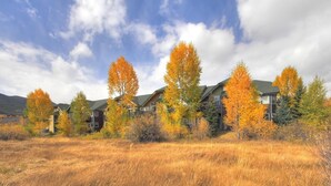 A row of multi-story buildings with a natural landscape in the foreground. - Tarn Landing  #c-4 2 Bedroom Condo by RedAwning (Frisco)