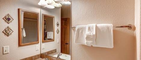 A bathroom with a sink, mirror, and three light fixtures above it.