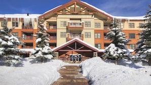 A multi-story hotel with a central entrance, balconies, and snow-covered surroundings. - Copper Springs  209 2 Bedroom Condo by RedAwning (Copper Mountain)