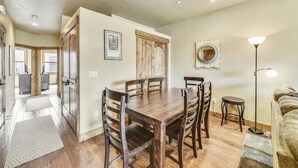 A dining area with a wooden table and chairs, a framed picture on the wall, and a floor lamp. - S Off Main  #4 2 Bedroom Condo by RedAwning (Frisco)