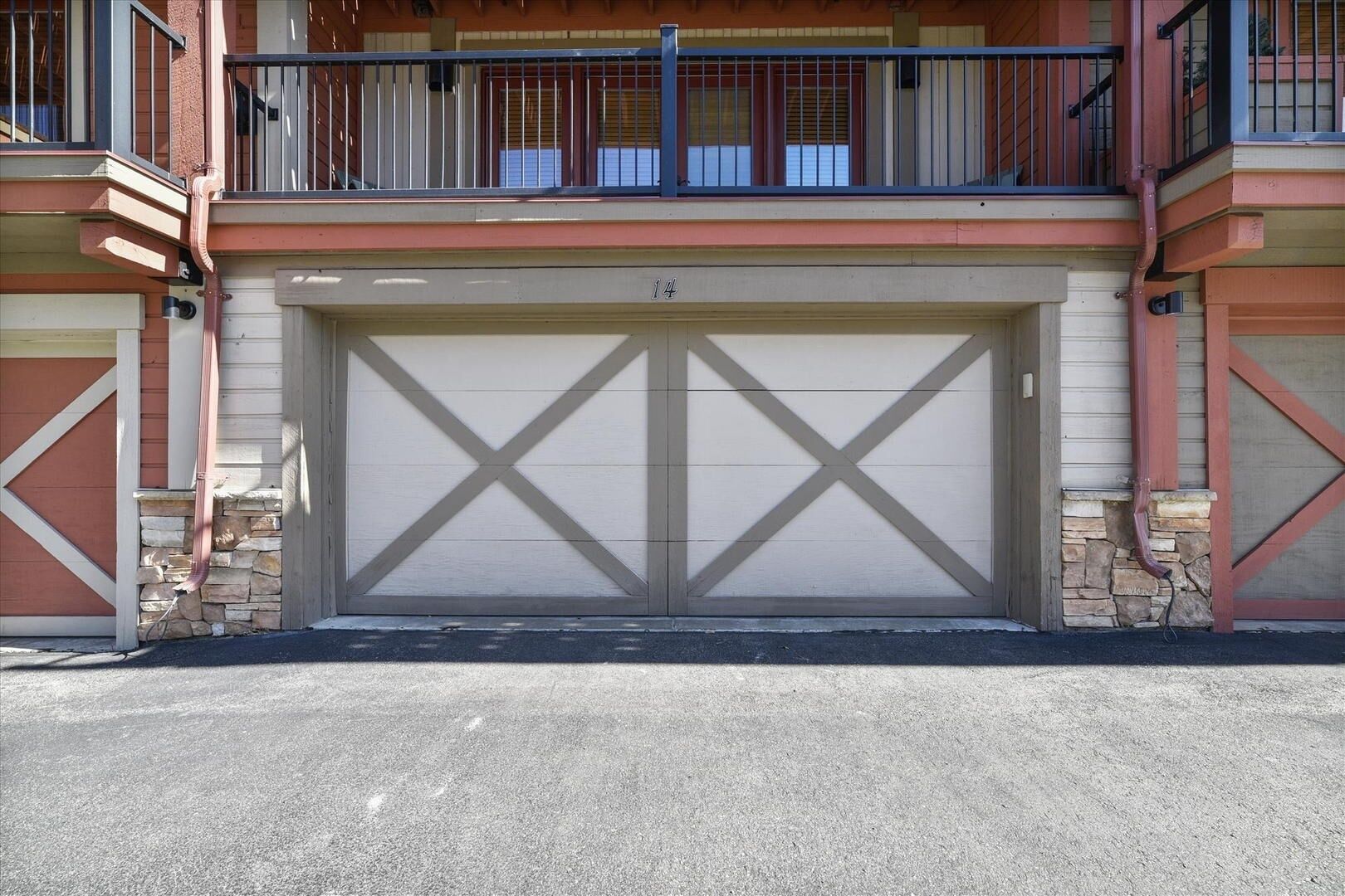 Un bâtiment à deux étages doté d’une porte de garage et d’un balcon.