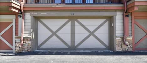 Un bâtiment à deux étages doté d’une porte de garage et d’un balcon.