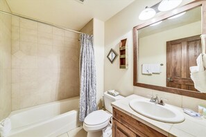 A bathroom with a bathtub, toilet, sink, and a large mirror. - Marina Park  14c 3 Bedroom Townhouse by RedAwning (Frisco)