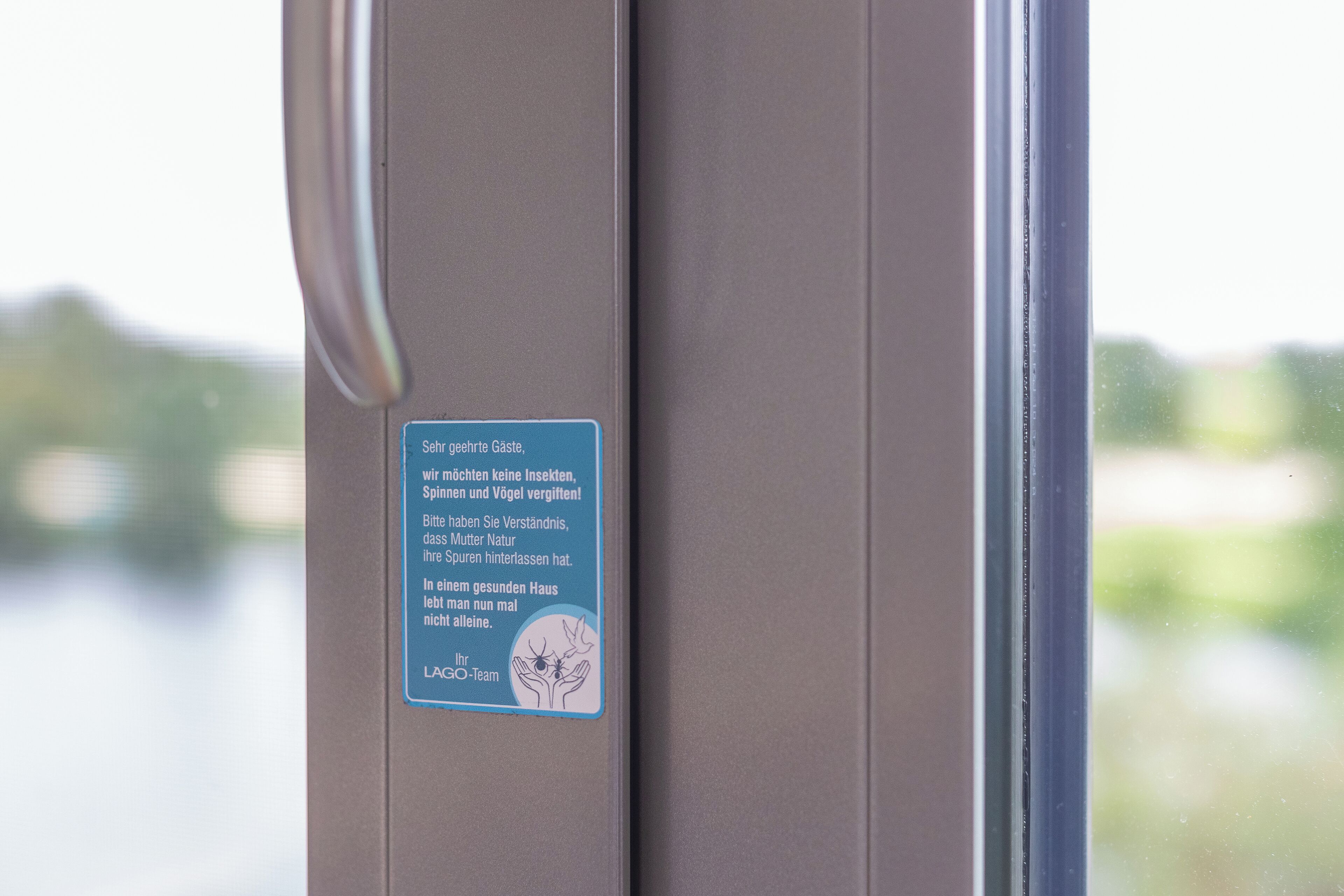 Ein Schild an einer Fahrzeugtür mit deutschem Text, das vor Insekten, Spinnen und Schlangen warnt.