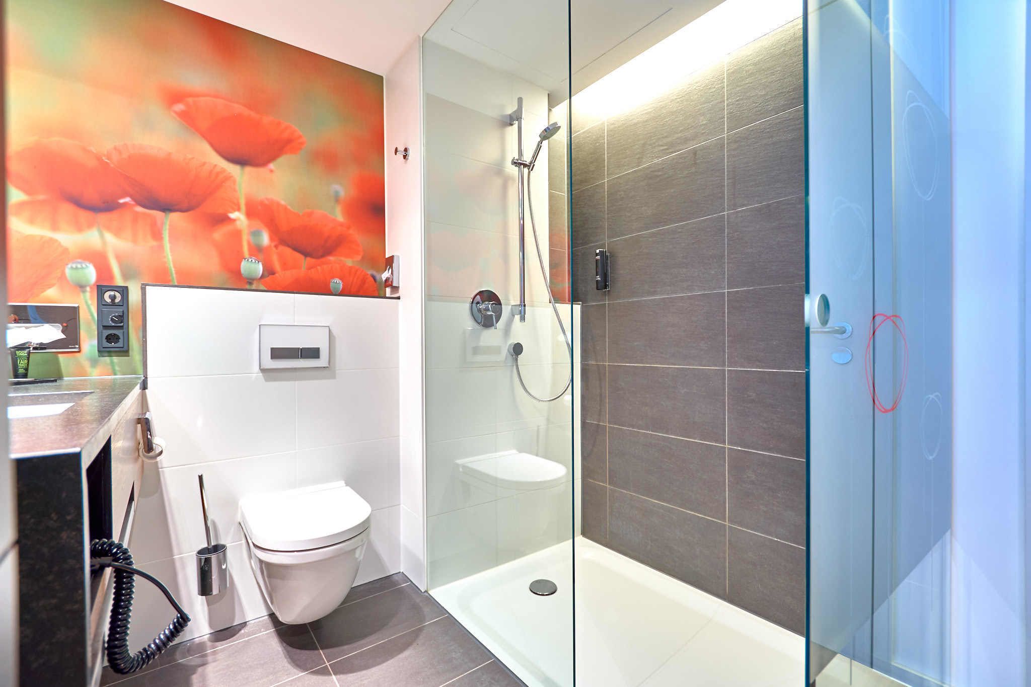 Un baño moderno con ducha envuelta en vidrio, inodoro y lavamanos.