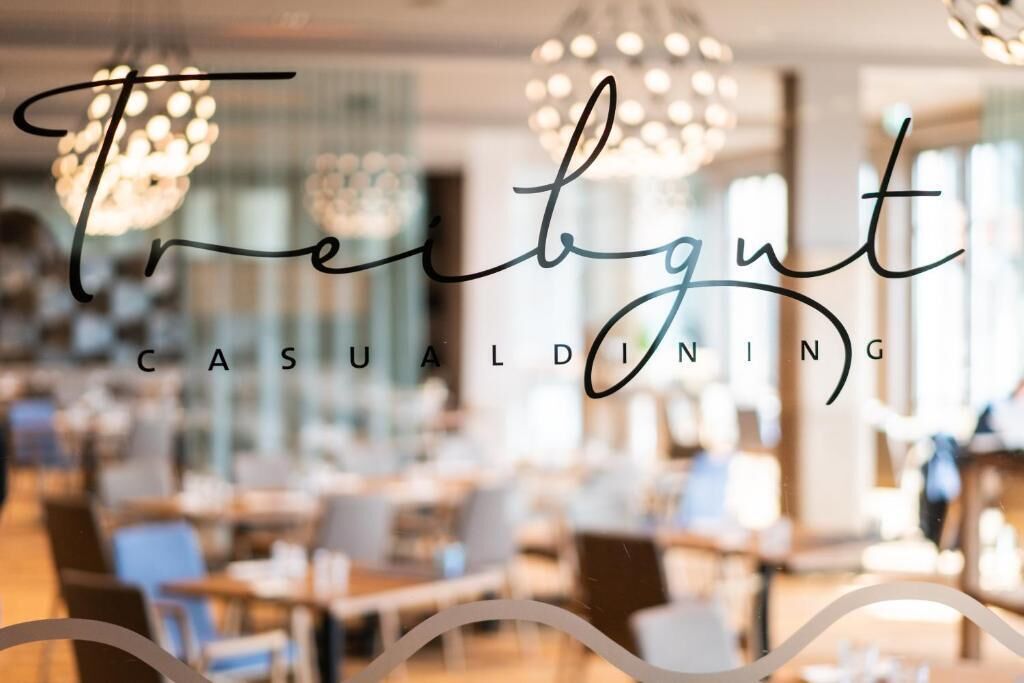 Un interior de restaurante con un diseño moderno, con candelabros y ambiente relajado.