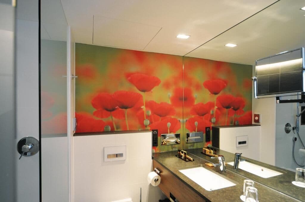 Un baño moderno con un espejo grande, dos lavamanos y una zona de ducha.