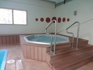 A hot tub with metal steps and a window.
