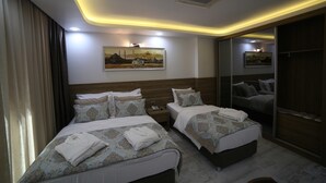 A hotel room with two beds, a large mirror, and a painting on the wall. - Grand Serenay Hotel (Bandirma)