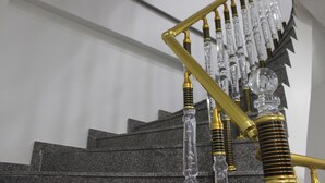 A staircase with a modern design featuring glass and metal elements. - Grand Serenay Hotel (Bandirma)