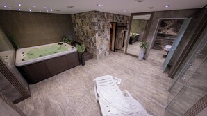 Un espace spa moderne comprenant un jacuzzi, une table de massage et un espace douche.