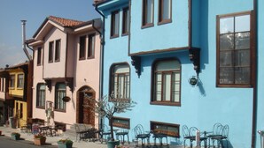 Une rangée de bâtiments aux couleurs vives, dotés d’une architecture traditionnelle, avec notamment une porte et des fenêtres bien visibles.