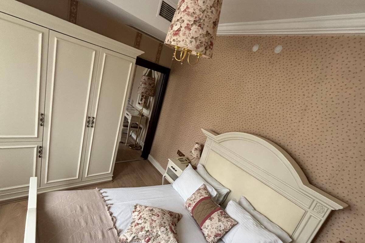 Ein Schlafzimmer mit Bett, Nachttischen, einem Schminktisch und einer Hängeleuchte.
