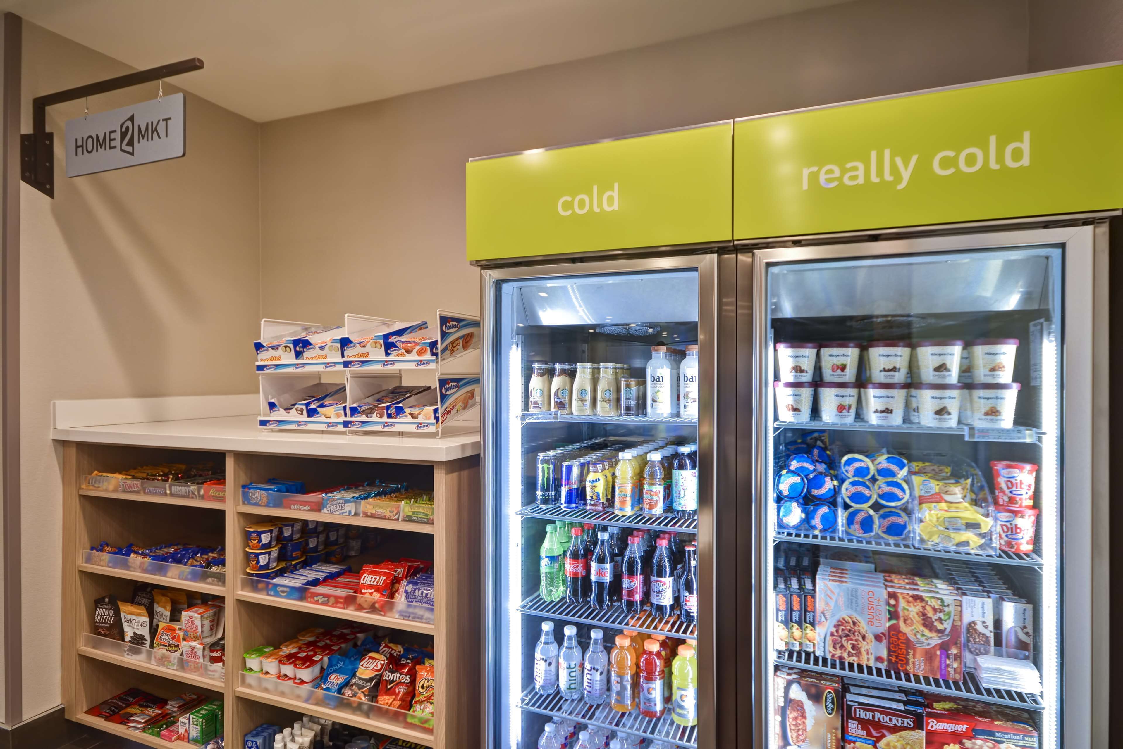 En køledisk med forskellige fødevarer og drikkevarer, herunder mejeriprodukter og snacks.