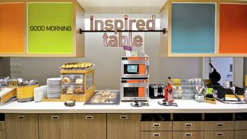 Un buffet pour le petit-déjeuner proposant une variété d’aliments et une machine à café.