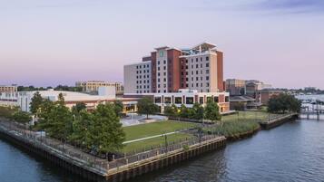 A waterfront hotel with a dock, a grassy area, and a parking lot.