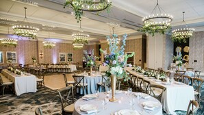 A banquet hall with round tables set for dining, chandeliers, and floral centerpieces. - Embassy Suites by Hilton Wilmington Riverfront (Wilmington)