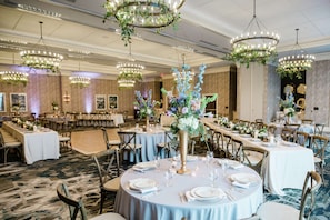 A banquet hall with round tables set for dining, chandeliers, and floral centerpieces. - Embassy Suites by Hilton Wilmington Riverfront (Wilmington)