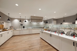Een modern ontbijtbuffet met verschillende stations, waaronder een warme buffetzone.