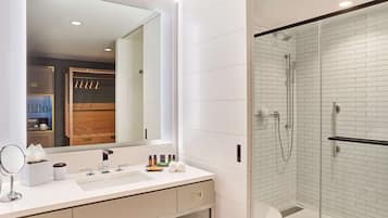 A modern bathroom with a white sink, mirror, and shower.