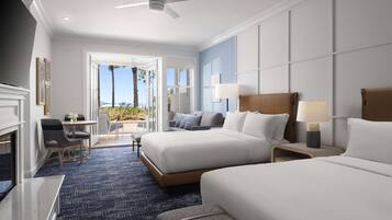 A hotel room with two beds, a desk, a chair, a lamp, and a view of the outdoors.