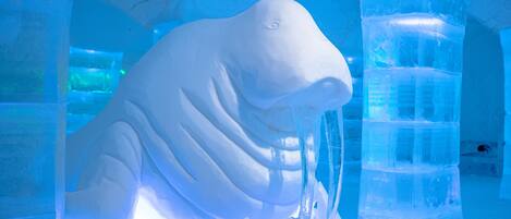 An ice sculpture of a walrus in a blue-lit enclosure.