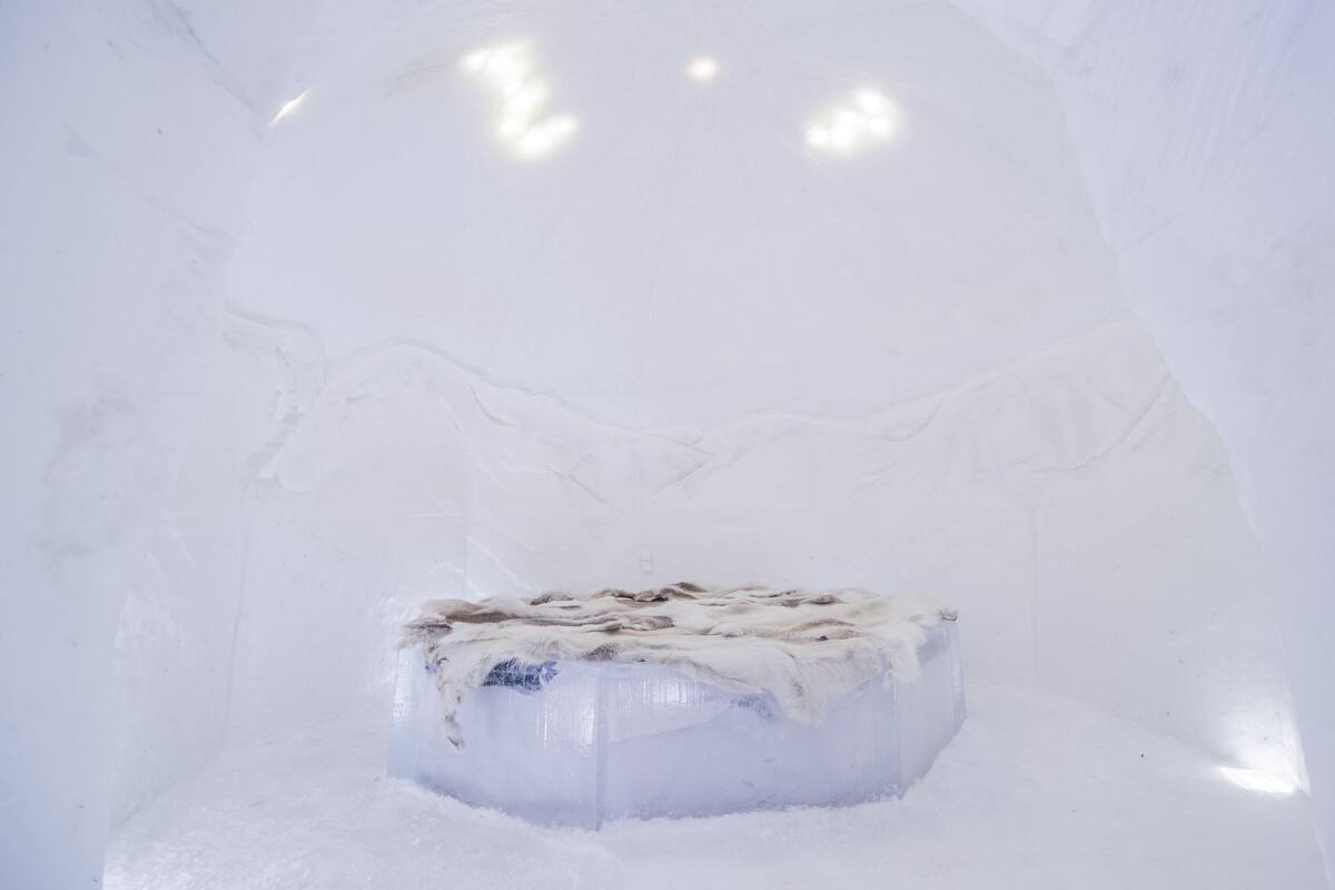 Uma iglu de gelo com um pequeno banco no interior.