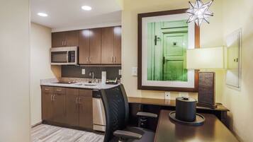 A compact kitchen with modern appliances, a dining area with a table and chairs, and a unique star-shaped light fixture.
