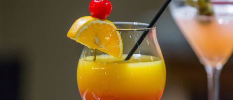 A cocktail with a cherry and orange slice garnish.