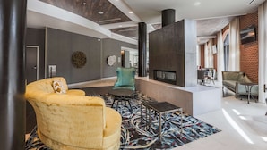 Un hall d’entrée moderne doté d’une cheminée, d’un espace salon et d’un tapis à motifs.