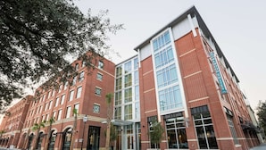 Un hôtel à plusieurs étages, doté d’une façade en briques, de grandes fenêtres et d’une enseigne indiquant qu’il s’agit d’un établissement de la chaîne Homewood Suites.
