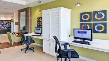 A reception area with two computer workstations, a white cabinet, and a green chair.