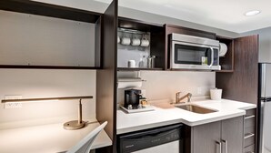 A modern kitchen with a built-in microwave, coffee maker, and dishwasher. - Home2 Suites by Hilton Azusa (Azusa)