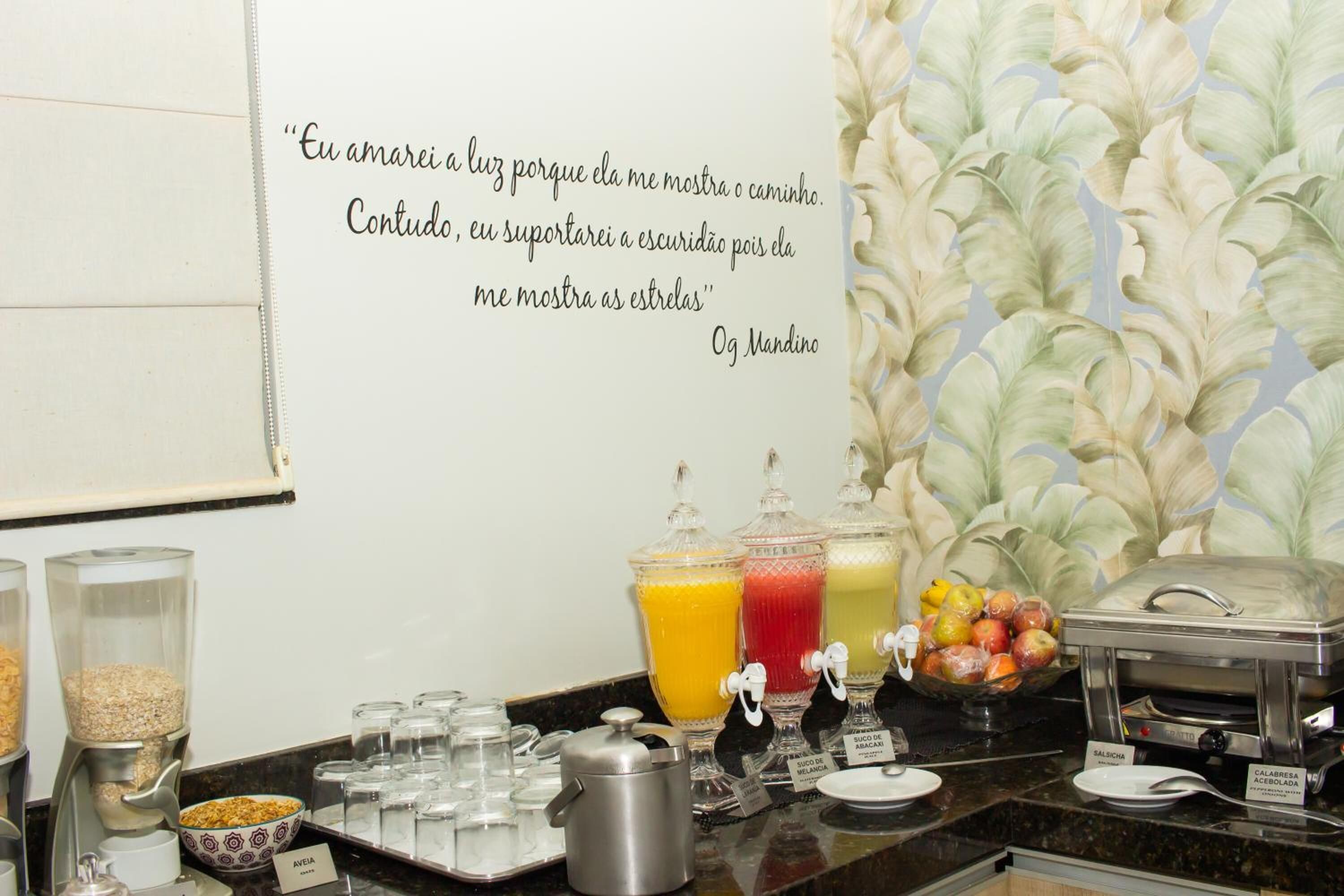 A breakfast buffet with various food and drink options, including fruit, cereal, and juice.
