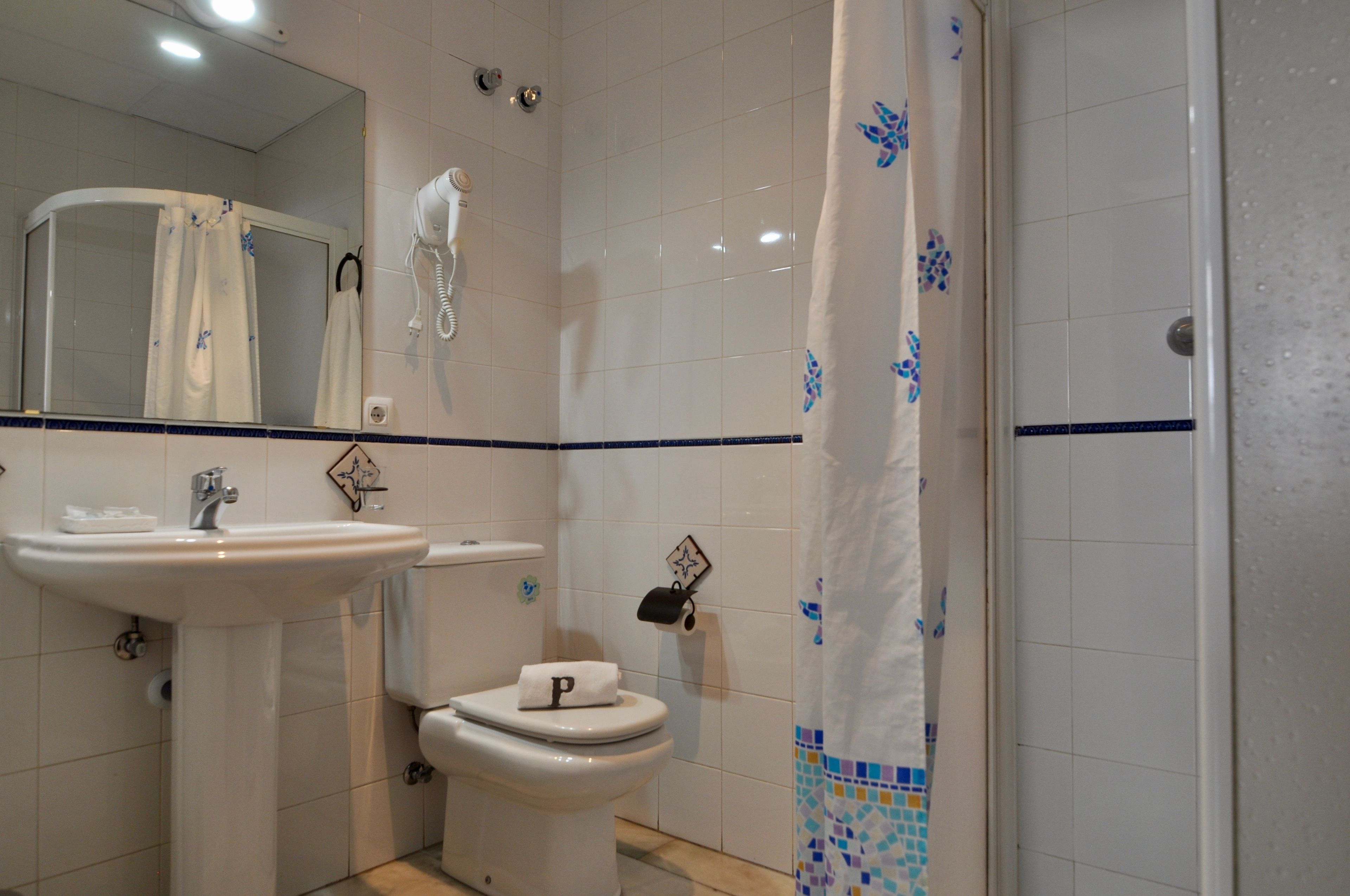 Een badkamer met een wastafel, toilet en douche.
