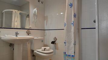Een badkamer met een wastafel, toilet en douche.